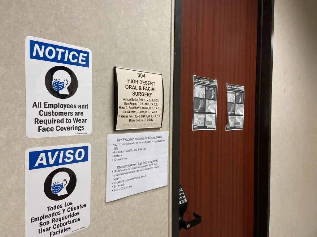Entrance to High Desert Oral & Facial Surgery with signs requiring face coverings