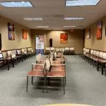 Spacious waiting room at High Desert Oral & Facial Surgery with multiple rows of chairs and wall art
