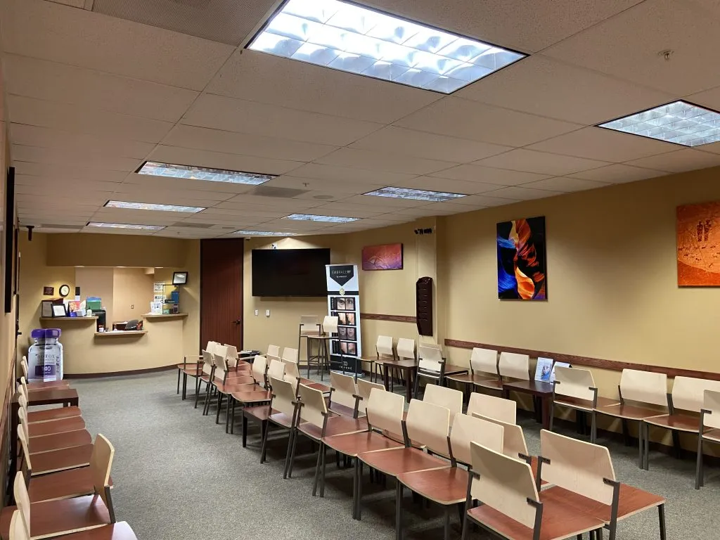Spacious waiting room at High Desert Oral & Facial Surgery with multiple rows of chairs and wall art