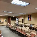 Spacious waiting room at High Desert Oral & Facial Surgery with multiple rows of chairs and wall art