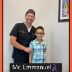 Dr. David Yates poses with a smiling pediatric patient
